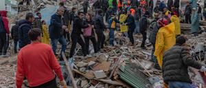 Menschen suchen nach einem Erdbeben in Adana, Türkei, in Trümmern.