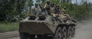 Ukrainische Soldaten fahren auf einem Mannschaftstransportwagen an der Frontlinie. 