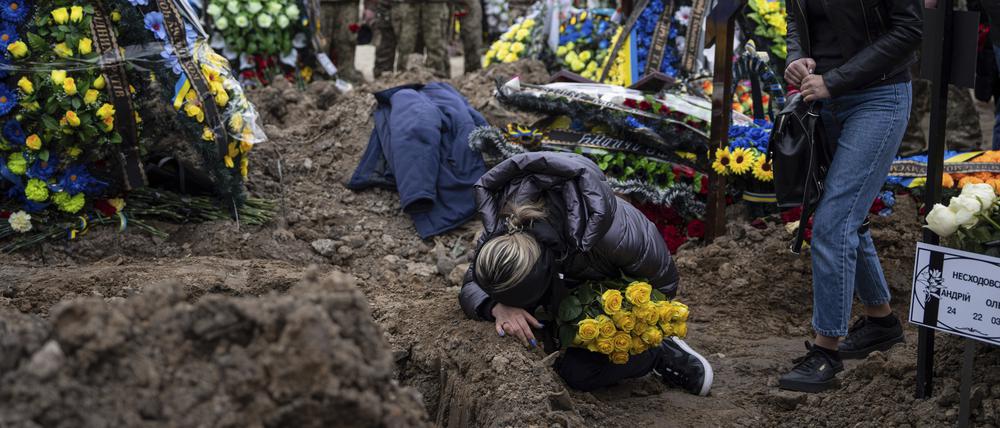 Eine Ukrainerin weint in Kiew am Grab ihres gefallenen Mannes.