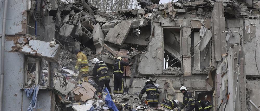 Feuerwehrleute des staatlichen ukrainischen Katastrophenschutzes inspizieren ein beschädigtes Haus nach einem russischen Raketeneinschlag. 