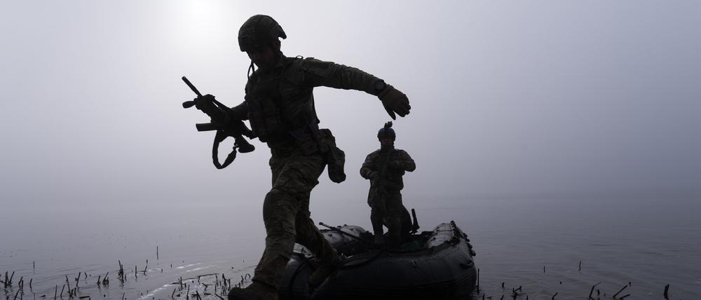 Ukraine, Cherson: Ein ukrainischer Soldat springt am Ufer des Dnipro-Flusses.