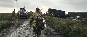 Ukrainische Soldaten stehen auf einer Landstraße in der Region Charkiw.