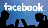 Die Schatten von Jugendlichen mit einem Laptop sind vor dem Schriftzug des sozialen Internet-Netzwerks Facebook zu sehen. Foto: Armin Weigel/dpa