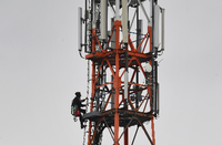 Ein Techniker klettert an einem Funkmast neben Mobilfunkantennen für den Mobilfunkstandard 5G. Foto: dpa/Stefan Sauer/zb