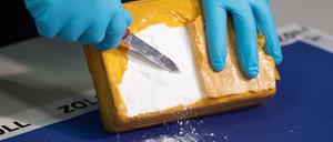 Ein Zollbeamter öffnet während einer Pressekonferenz ein Paket mit Kokain, das von den Beamten sichergestellt wurde.
