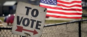 Ein Wahlschild und eine amerikanische Flagge sind vor einem Vorwahlbüro in Dearborn, Michigan zu sehen. Michigan ist der letzte große Vorwahlstaat vor dem Super Tuesday und ein entscheidender Staat für die Parlamentswahlen im November. 