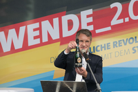 Björn Höcke (AfD), hatte in Cottbus eine Flasche Sekt als symbolisches Geschenk für Brandenburgs Innenminister Schröter (SPD) mitgebracht. Foto: Jörg Carstensen/dpa