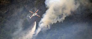 Ein Hubschrauber wirft Wasser auf die Flammen.