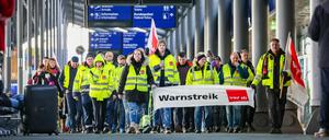 Beschäftigte der Mitteldeutschen Flughafen AG gehen während eines Warnstreiks durch den Flughafen Leipzig/Halle. 