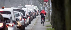 Radfahrer fahren an der Bundesstrasse 105 in der Rostocker City entlang am Stau im Berufsverkehr. 