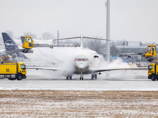 Ein Flugzeug wird kurz vor dem Start nahe der Startbahn auf dem Taxiway am Münchner Flughafen enteist.