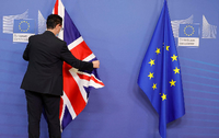 Ein Mitglied des Protokolls richtet die EU- und Fahne Großbritanniens vor einem Treffen im EU-Hauptquartier. Foto: Olivier Matthys/AP/dpa