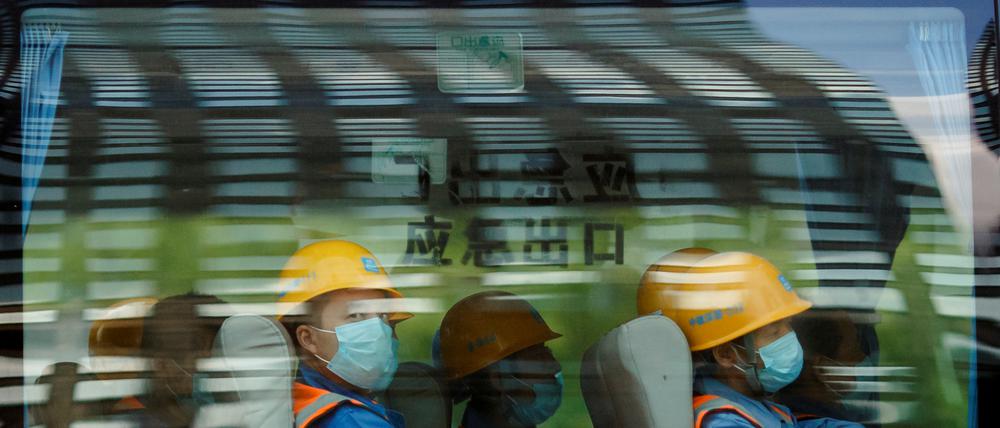 Arbeiter verlassen eine Baustelle im Finanzdistrikt von Peking am Ende ihrer Schicht. Die Abkühlung des Bausektors verlangsamt das Wirtschaftswachstum in China.