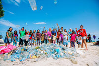 Mit einheimischen Kindern sammeln die Resortmitarbeiter Plastikmüll am Strand auf. Foto: Soneva