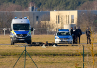 Flugzeugabsturz in Strausberg: Zwischen zwei Fahrzeugen der Polizei sind die verkohlten Reste eines Kleinflugzeuges zu sehen. Foto: Foto: Patrick Pleul/dpa-Zentralbild/dpa