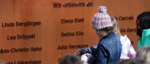 Schüler legen bei einer Gedenkfeier Rosen vor eine Gedenktafel mit den Namen der verstorbenen Opfer das Absturzes der Germanwings-Maschine (Archivbild). 