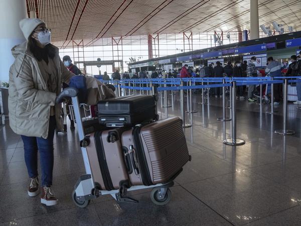  Eine Reisende kommt am Check-in-Schalter für internationale Flüge auf dem Beijing Capital International Airport in Peking an. 
