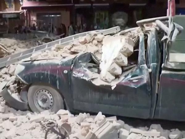 Blick auf ein beschädigtes Auto und Trümmer des Erdbebens in Marrakesch.