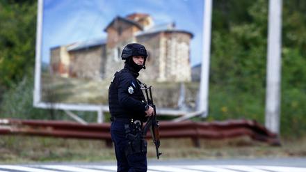 Ein Kosovo-Polizist steht nach einer Schießerei auf der Straße zum Banjska-Kloster Wache.