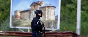 Ein Kosovo-Polizist steht nach einer Schießerei auf der Straße zum Banjska-Kloster Wache.