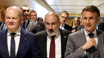 Der armenische Premierminister Nikol Pashinyan geht neben Bundeskanzler Olaf Scholz und dem französischen Präsidenten Emmanuel Macron vor Beginn einer Plenarsitzung des Gipfels der Europäischen Politischen Gemeinschaft im Kongresspalast in Granada.