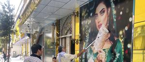  Ein Mitarbeiter eines Schönheitssalons übermalt ein großes Foto einer Frau an der Wand, nachdem die Taliban in die afghanische Hauptstadt Kabul eingedrungen sind. (Archivbild)