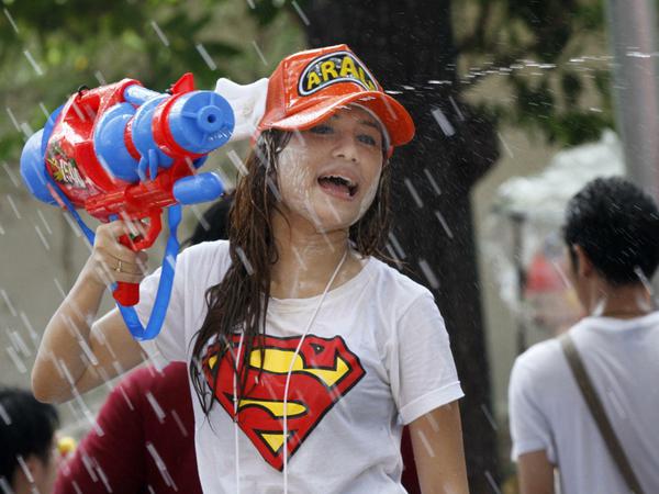 Universales Symbol: Eine junge Frau mit Superman-Shirt auf dem Bangkoker Songkran-Festival.