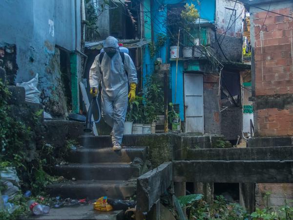 Anwohner im Schutzanzug. Bürgersteig in einer Favela in Brasilien.