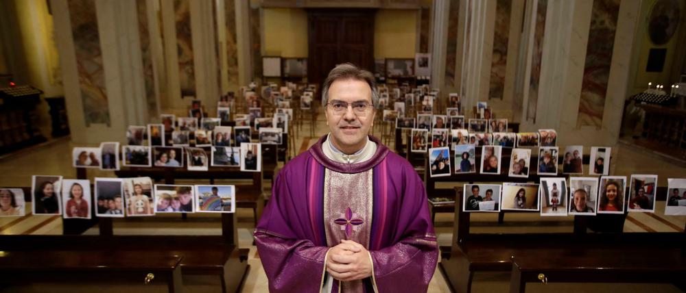 Auch Kirchen sind von den Einschränkungen betroffen. Pfarrer Don Giuseppe Corbari vor den Selfies seiner Gemeindemitglieder.