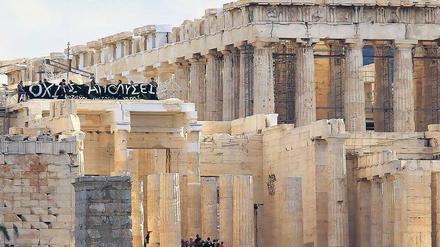 Erhabene Baustelle. Touristen auf der Akropolis – und ein Transparent, das gegen die Sparpolitik der Regierung protestiert. 