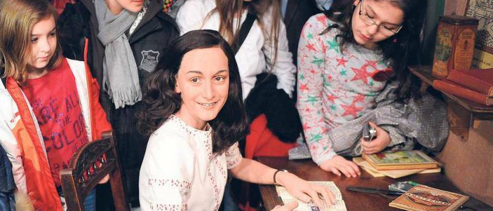 Was schreibt sie? Anne Franks Wachsfigur in der Berliner Ausstellung von Madame Tussauds, mit ihrem berühmten Tagebuch, aus dem immer wieder unbekannte Passagen auftauchen. Foto: p-a / dpa