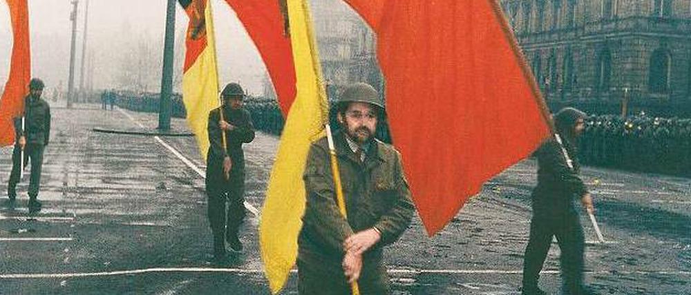 Der dissidente Blick. 1988 fotografierte Jens Rötzsch in Leipzig die Parade der Arbeiter-Kampfgruppe, an deren Ende die rote Fahne und die Flagge des Arbeiter- und Bauernstaats eher müde flatterten. 