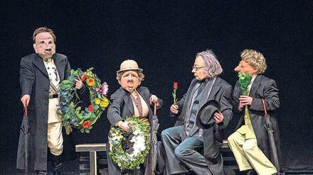 Die Maskenspieler der Theatertruppe Familie Flöz verkleidet als Trauergäste. 