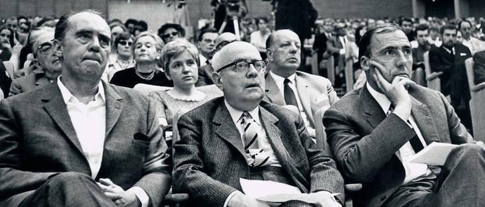 Engagement im öffentlichen Raum. Der Schriftsteller Heinrich Böll, der Philosoph Theodor W. Adorno und Suhrkamp-Verleger Siegfried Unseld (v.l.) unterstützen den Protest gegen die Notstandsgesetze. Eine Veranstaltung im Großen Sendesaal des Hessischen Rundfunks in Frankfurt am Main am 28. Mai 1968. 