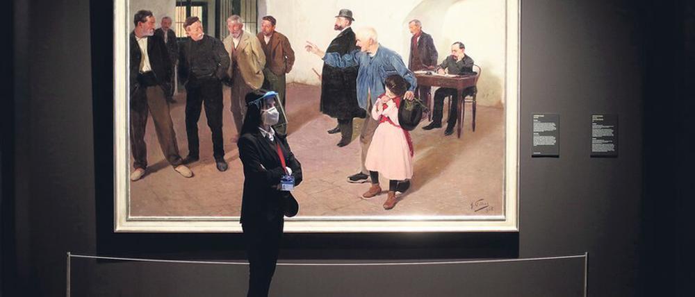 Platz im Prado. Eine Frau mit Gesichts- und Mundschutz vor einem Gemälde von Antoni Fillol auf der aktuellen Sonderausstellung „Guests“. 