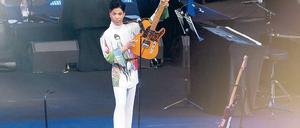 Triumphator. Prince präsentiert sein Herrschaftsinstrument. Das Seidenhemd zeigt das Plakatmotiv zur Tournee. Foto: Eventpress
