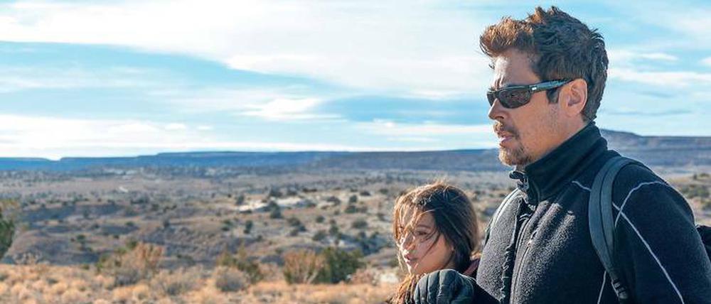 Der Killer (Benicio del Toro) und die Tochter des Drogenbosses (Isabela Moner) marschieren zu Fuß durch die Wüste. 