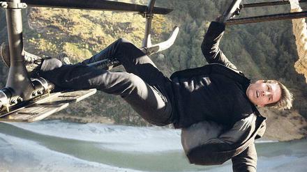 Voller Einsatz. Ethan Hunt (Tom Cruise) entspannt sich in luftiger Höhe an der Kufe eines Helikopters.