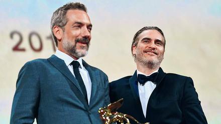 Regisseur Todd Phillips (links) und sein Hauptdarsteller Joaquin Phoenix verstehen die Welt nicht mehr. Mit „Joker“ gewinnt erstmals ein Superheldenfilm den Goldenen Löwen. 
