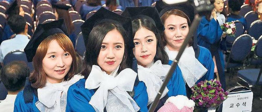Auch in Deutschland längst zu haben. Südkoreanische College-Studentinnen mit einem ausziehbaren Stativ für das Selfie.