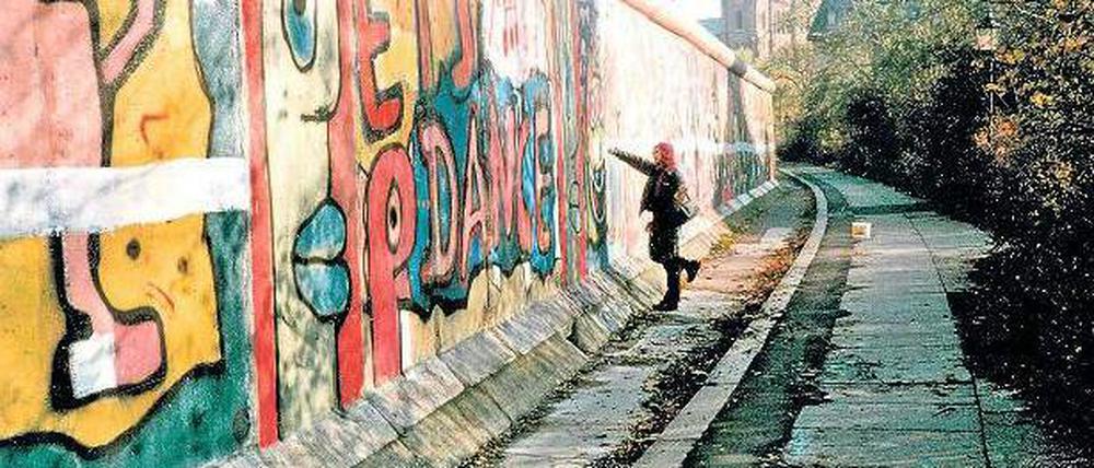 Antifaschistischer Schutzwall, Ghettomarkierung, Bildfläche. Die Mauer in den achtziger Jahren von der Kreuzberger Seite - und eine Aktionskünstlerin bei der Arbeit. Foto: Salzgeber