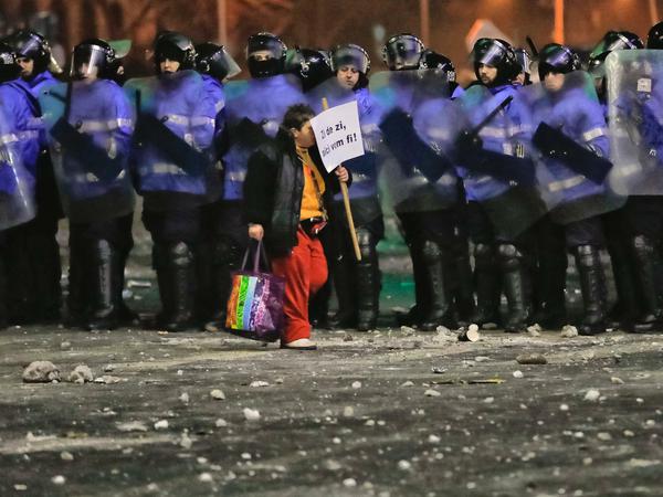 Proteste gegen Korruptio: Ein Demonstrant mit einem Schild auf dem «Wir werden hier jeden Tag sein» steht, geht am 02.02.2017 in Bukarest an einer Reihe rumänischer Bereitschaftspolizisten entlang. 