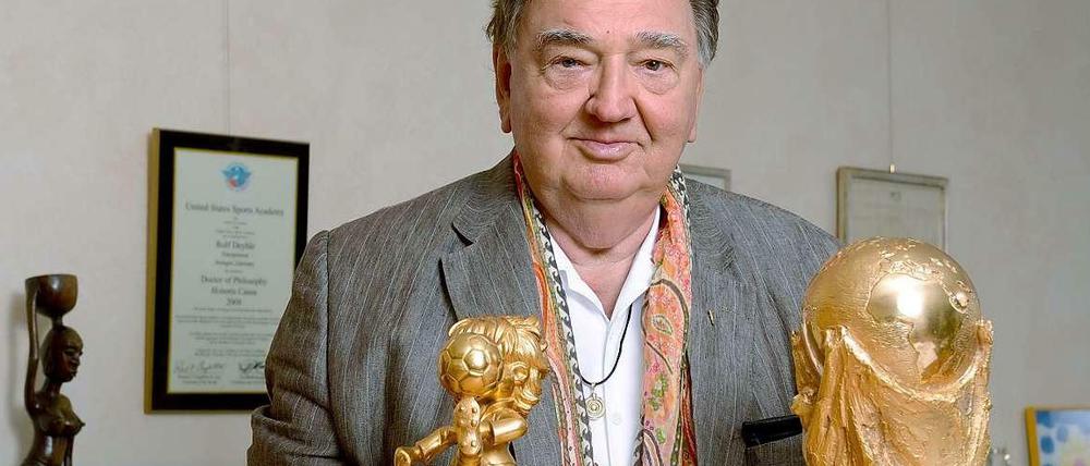 Der Unternehmer Rolf Deyhle im September 2013 in seinem Stuttgarter Büro mit Kopien der FIFA-Trophäen Fair Play und Weltpokal, die er als Anerkennung für seine Verdienste um den Weltfußball erhalten hat