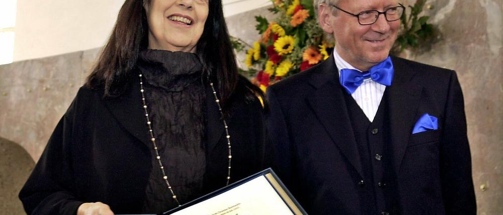 Die US-amerikanische Schriftstellerin Susan Sontag zeigt am Sonntag am 12.10.2003 während der Friedenspreis-Verleihung des Deutschen Buchhandels in der Frankfurter Paulskirche mit Dieter Schormann, dem Vorsteher des Börsenvereins.