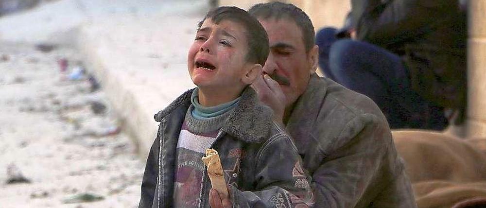 A boy cries at a site hit by what activists say was an airstrike by forces loyal to Syrian President Assad in Masaken Hanano in Aleppo February 14, 2014.