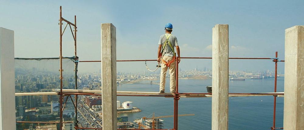 Ein Bauarbeiter auf der Baustelle mit Aussicht auf Beirut.