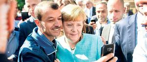Angela Merkel und ein Flüchtling beim „größten Sozialexperiment Europas seit der Russischen Revolution“ (Sarrazin). 
