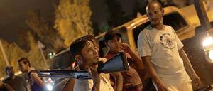 Junge Männer versammeln sich in der Nacht zu Samstag und stürmen das Quartier einer militanten Miliz in Benghasi, Libyen.