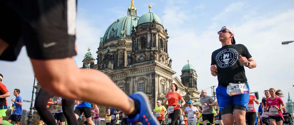 Teilnehmer laufen während des 37. Halbmarathon in Berlin am Berliner Dom vorbei.