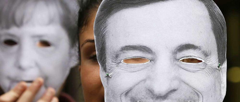 Demonstranten in Italien mit Masken von Angela Merkel und Mario Draghi. 